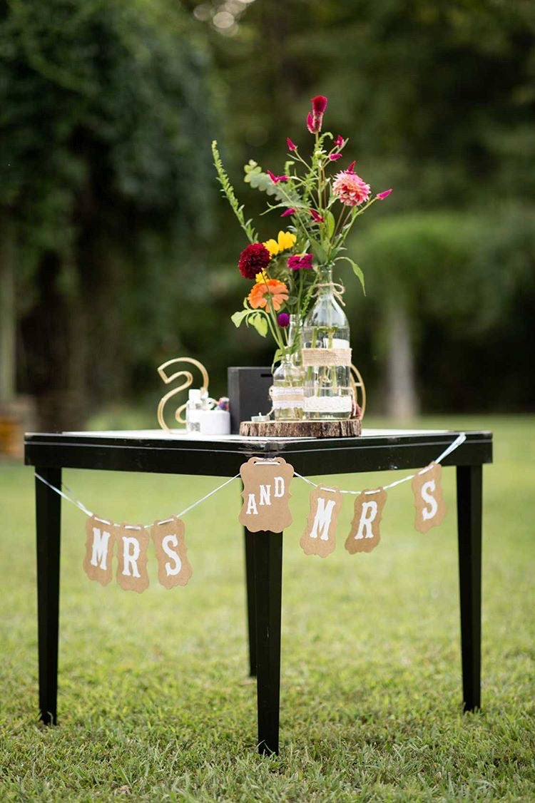 Mrs and Mrs Brown Craft Banner Hanging from a Black Table Decorated with Flowers