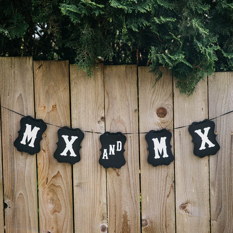 Mx and Mx Black Craft Banner Hanging from Wooden Fence