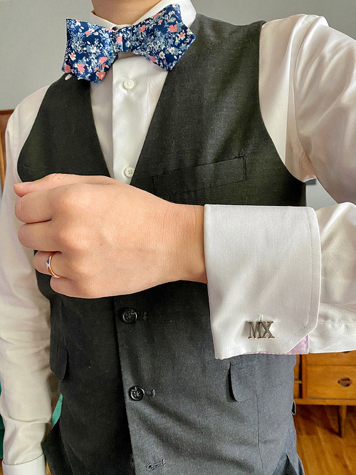 Person in Suit with Floral Bowtie Wearing Mx Cufflinks